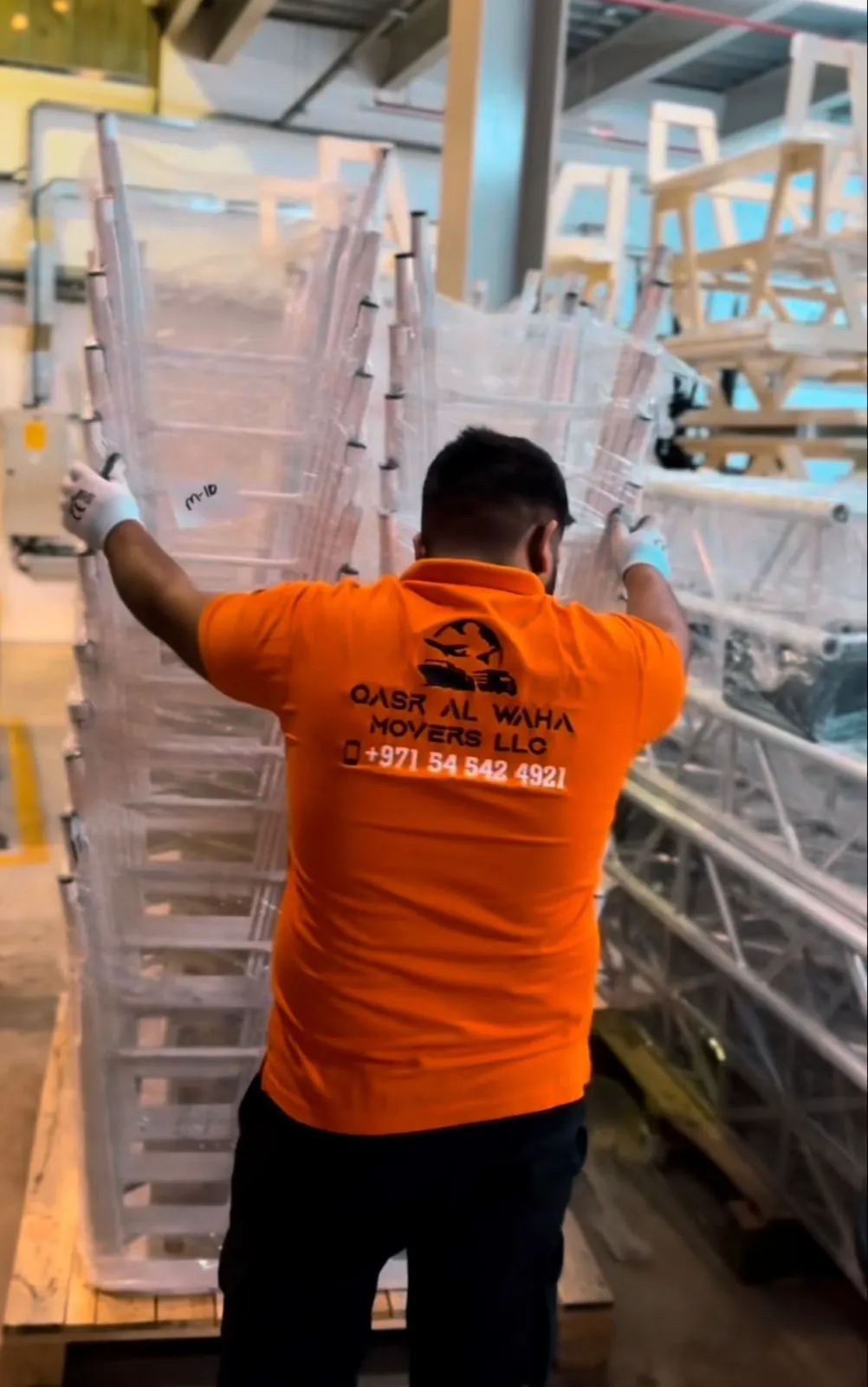 QASR AL WAHA Movers worker shrink-wrapping stacked furniture on a pallet — Movers from Dubai to Monaco